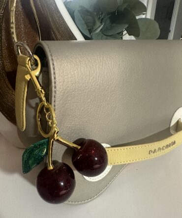 Llavero de cerezas con hojas verdes