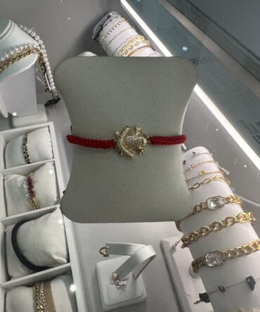 Aesthetic:  Pulsera de hilo rojo con dije del sapo concho en tono dorado