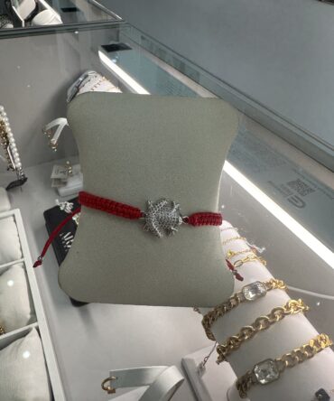 Aesthetic:  Pulsera en hilo rojo con dije del sapo concho en tono plateado