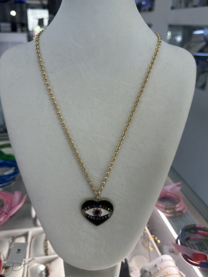 Aesthetic:  Collar en tono dorado con dije en forma de corazón y el ojo turco