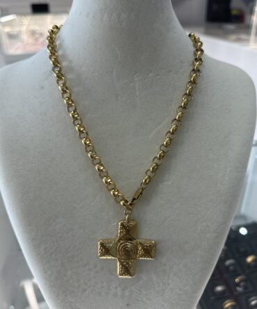 Acenttum: Collar maximalista con cruz en tono dorado