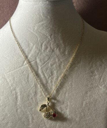 Aesthetic: Collar en tono dorado con dije en dorado y rojo en forma de cerezas